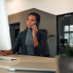 A woman talks to a client on the phone in a startup office