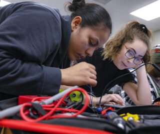 Two UIC computer science students work with tools in a lab