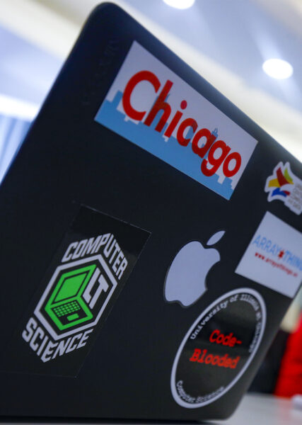 A laptop decorated with stickers relating to coding and the city of Chicago