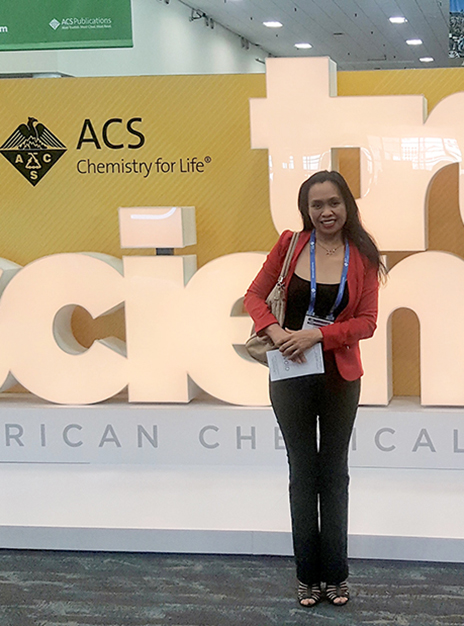 Doris Espiritu at the American Chemical Society conference, in front of a large logo reading 