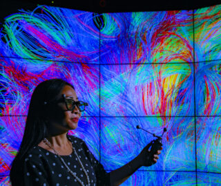 A woman manipulates a rainbow-colored data visualization in the renowned Electronic Visualization Lab at UIC