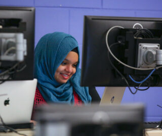A female student works at a desktop computer in the Computer Science Lounge at UIC