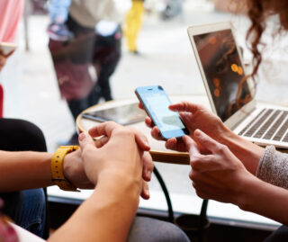 Two women share a look at a smartphone screen