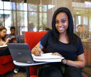 A student with her notebook and laptop in one of UIC's study spaces