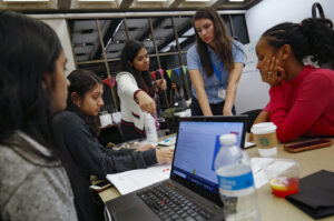 Four female UIC computer science students work together on an assignment with guidance from Dr. Shanon Reckinger