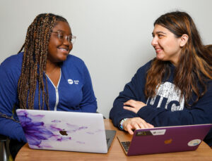 two UIC students work together on their laptops in the Engineering Innovation Building