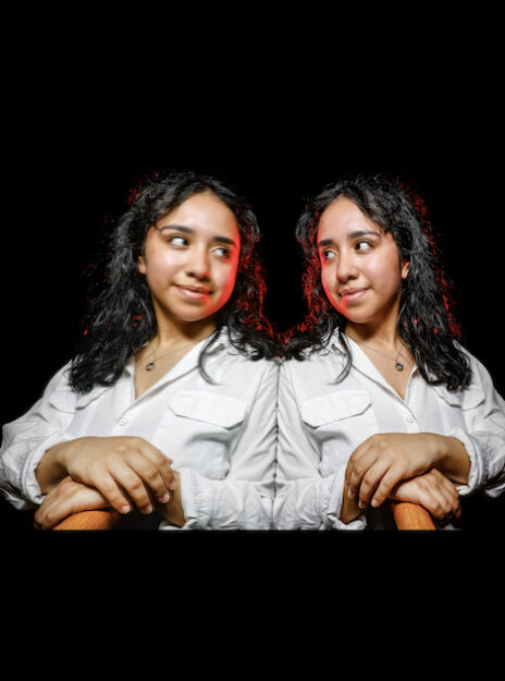 mirror-image style portrait of Monse Castillo against a dark black background